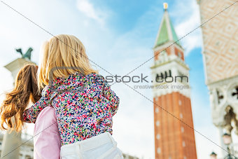 Mother and baby looking on campanile di san marco in venice, ita