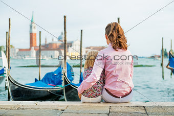 Portrait of mother and baby sitting on grand canal embankment in