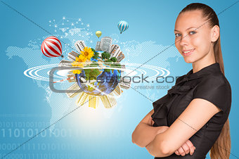 Beautiful businesswoman smiling and looking at camera.  Beside is miniature Earth with trees, houses etc.