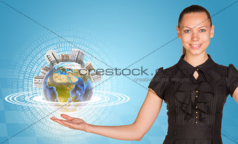 Beautiful businesswoman holding miniature Earth with houses on it.