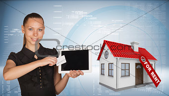 Beautiful businesswoman holding tablet PC.  Beside is house with tag for rent