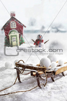 Wooden sled and snowballs with wintery background