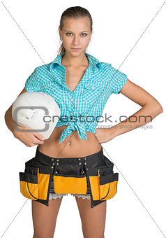Pretty girl in shorts, shirt and tool belt holding white helmet
