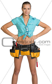 Pretty girl in shorts, shirt and tool belt with tools
