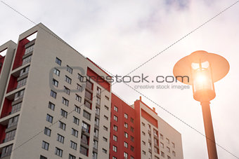 Glowing street light on background of high residential building