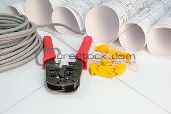 Drawing rolls, cat 5 cable, crimping pliers, connectors and boot caps composition