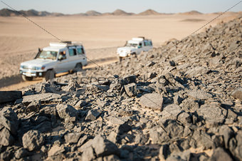 Vehicles driving through rocky desert