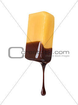 with a piece of caramel dripping chocolate on a white background
