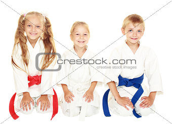 Cheerful young children to sit in a ceremonial kimono karate pose