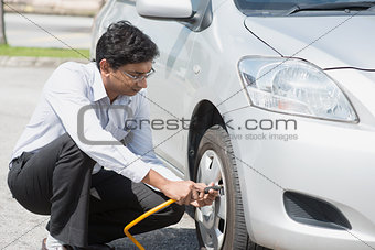 Indian people filling air to the car tires.