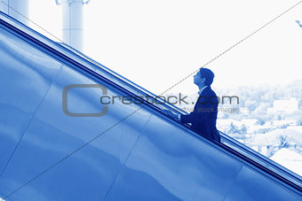Indian businessman ascending escalator