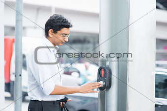 Indian people hand pushing a crosswalk button 