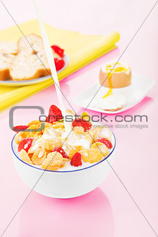 Delicious breakfast in pink and yellow. Cereal, egg and pastry.