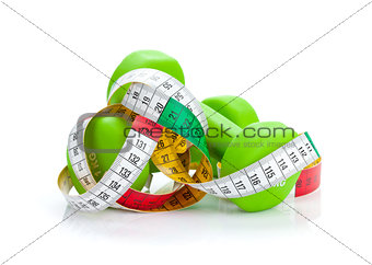 Two green dumbells and tape measure. Fitness and health
