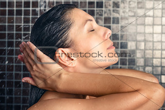 Attractive woman washing her hair in the shower