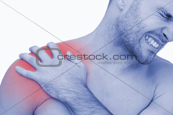 Young shirtless man with shoulder pain