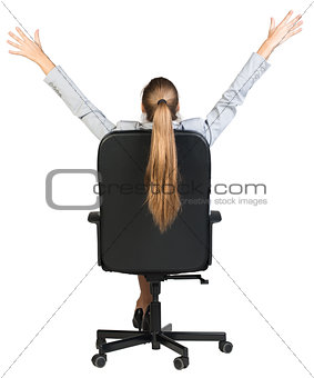 Businesswoman stretching in the chair of her office. Back view