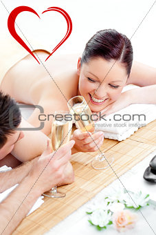 Composite image of loving young couple drinking champagne lying on a massage table