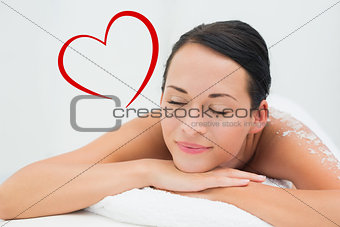Composite image of peaceful brunette lying with salt scrub on back