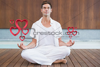 Composite image of handsome man in white meditating in lotus pose