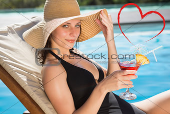 Composite image of beautiful woman holding drink by swimming pool