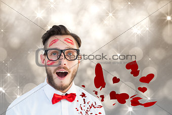 Composite image of geeky hipster with kisses on his face
