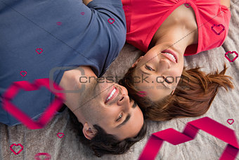 Composite image of two friends looking into the sky while lying on a quilt