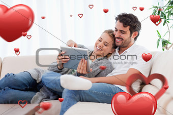 Composite image of in love couple using a tablet computer