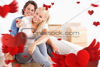 Composite image of woman sitting with her fiance giving keys
