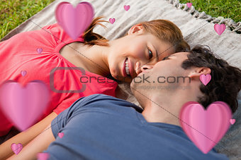 Composite image of woman looking into her friends eyes while lying on a quilt