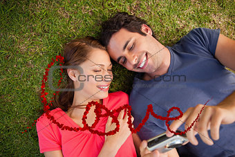 Composite image of two smiling friends looking at photos on a camera