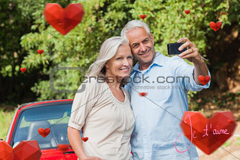 Composite image of cheerful mature couple taking pictures of themselves