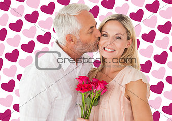 Composite image of affectionate man kissing his wife on the cheek with roses