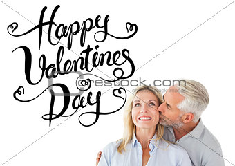 Composite image of affectionate man kissing his wife on the cheek