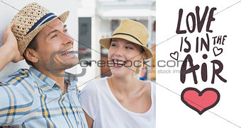 Composite image of young hip couple sitting on bench