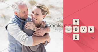 Composite image of happy hugging couple on the beach looking at each other