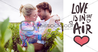 Composite image of smiling couple embracing outside among the bushes