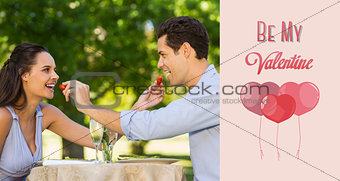 Composite image of couple feeding strawberries to each other at outdoor café