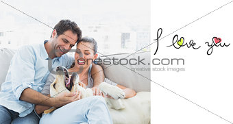 Composite image of happy couple petting their yellow labrador on the couch