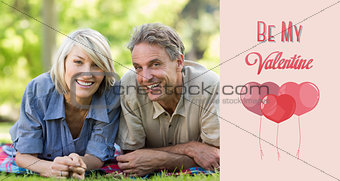 Composite image of couple lying on blanket in park