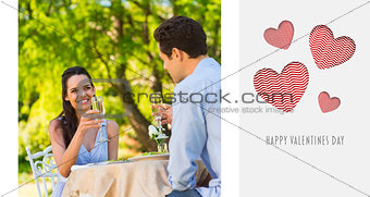Composite image of couple toasting champagne flutes at an outdoor café