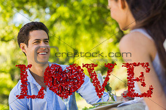 Composite image of couple with champagne flutes sitting at an outdoor café