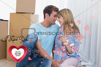 Composite image of couple holding new house key against cardboard boxes