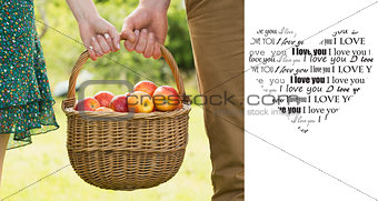 Composite image of basket of apples being carried by a young couple
