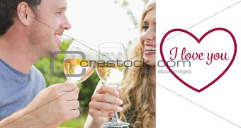 Composite image of cheerful couple toasting with white wine