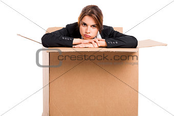 Stressed business woman inside a card box
