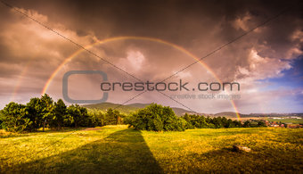 Double Rainbow over Landscape at Sunset