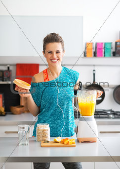 Portrait of happy fitness young woman making pumpkin smoothie in