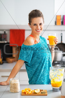 Portrait of smiling fitness young woman with glass of pumpkin sm