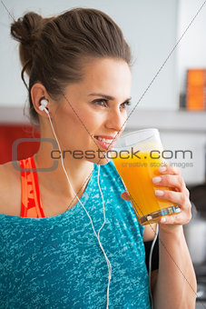 Happy fitness young woman drinking pumpkin smoothie